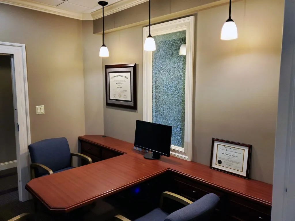 Desk with computer monitor and two chairs at {PRACTICE_NAME}