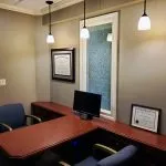 Desk with computer monitor and two chairs at {PRACTICE_NAME}