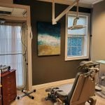 Dental chair, overhead light, and IV in patient room at {PRACTICE_NAME}