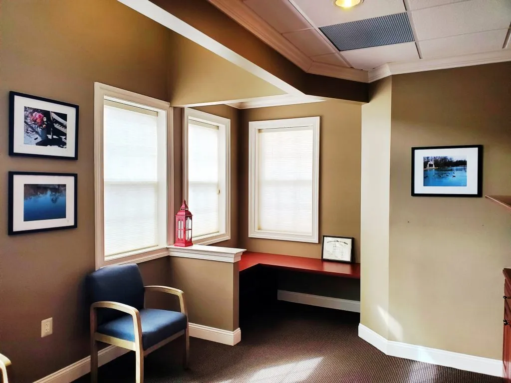 Chair and shelf in waiting room at {PRACTICE_NAME}